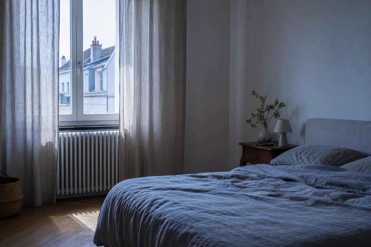 Radiateur blanc sous une fenêtre dans une chambre, lumière du matin